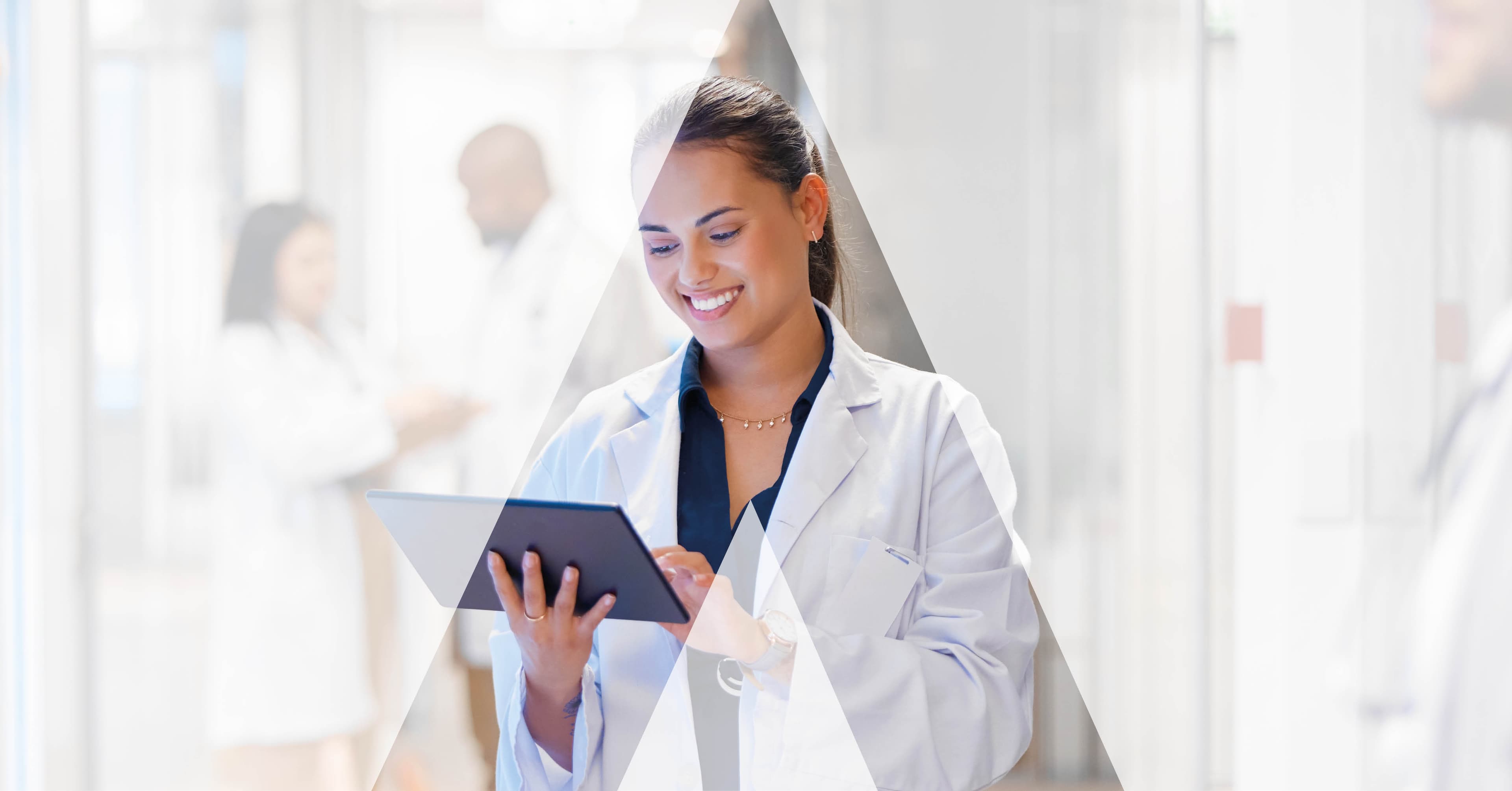 Clinician reviewing a tablet in a bright hospital corridor, representing the AI-assisted workflow a healthcare marketer learns to build