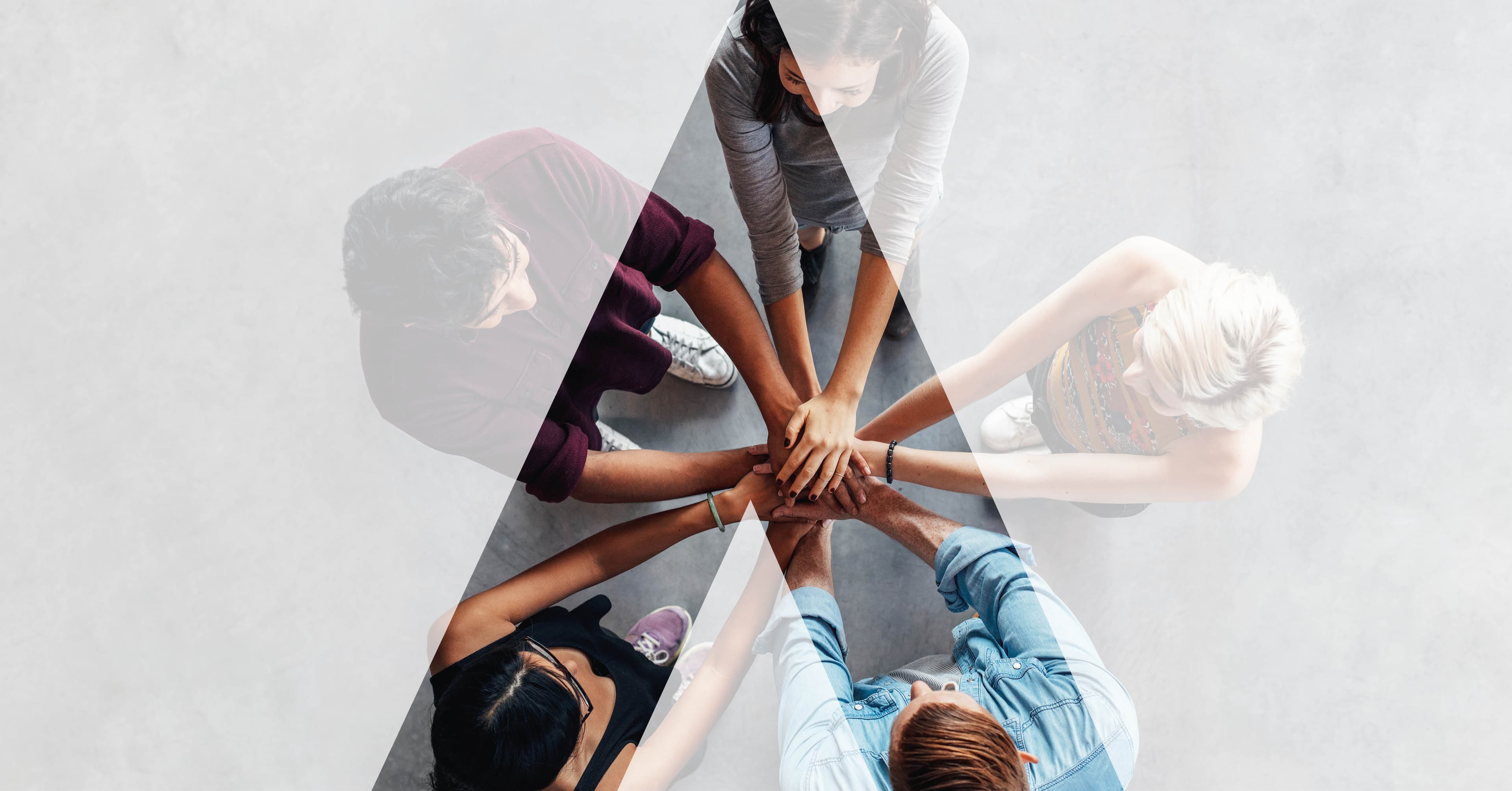 A diverse team in workshop, hands meeting in the centre - the AGENCY training format where teams work on their own products and markets, not generic case studies.